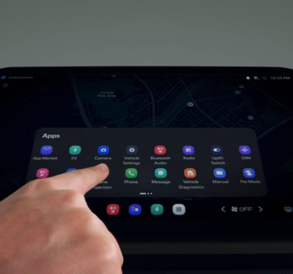 Ein Finger berührt den Touchscreen des Infotainmentsystems, der ein App-Menü im Fahrzeug anzeigt